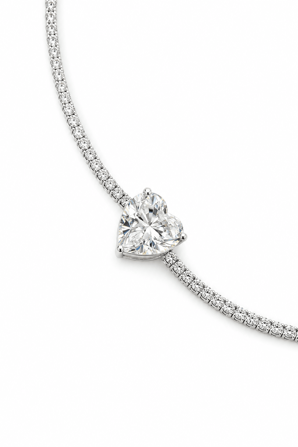 A close-up of a silver-plated bracelet with a heart-shaped crystal