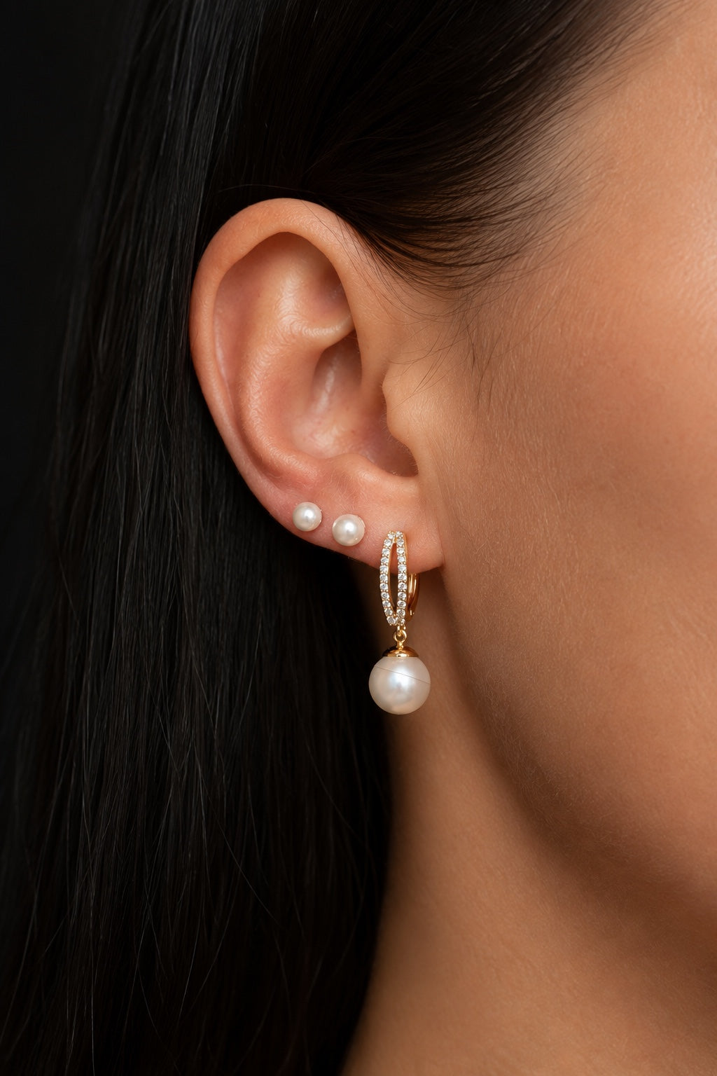 Pearl stud earrings in combination with hoop earrings