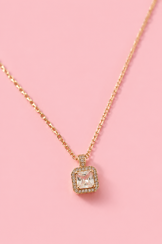 18k gold-plated necklace with a square pendant and clear zircons on a pink background