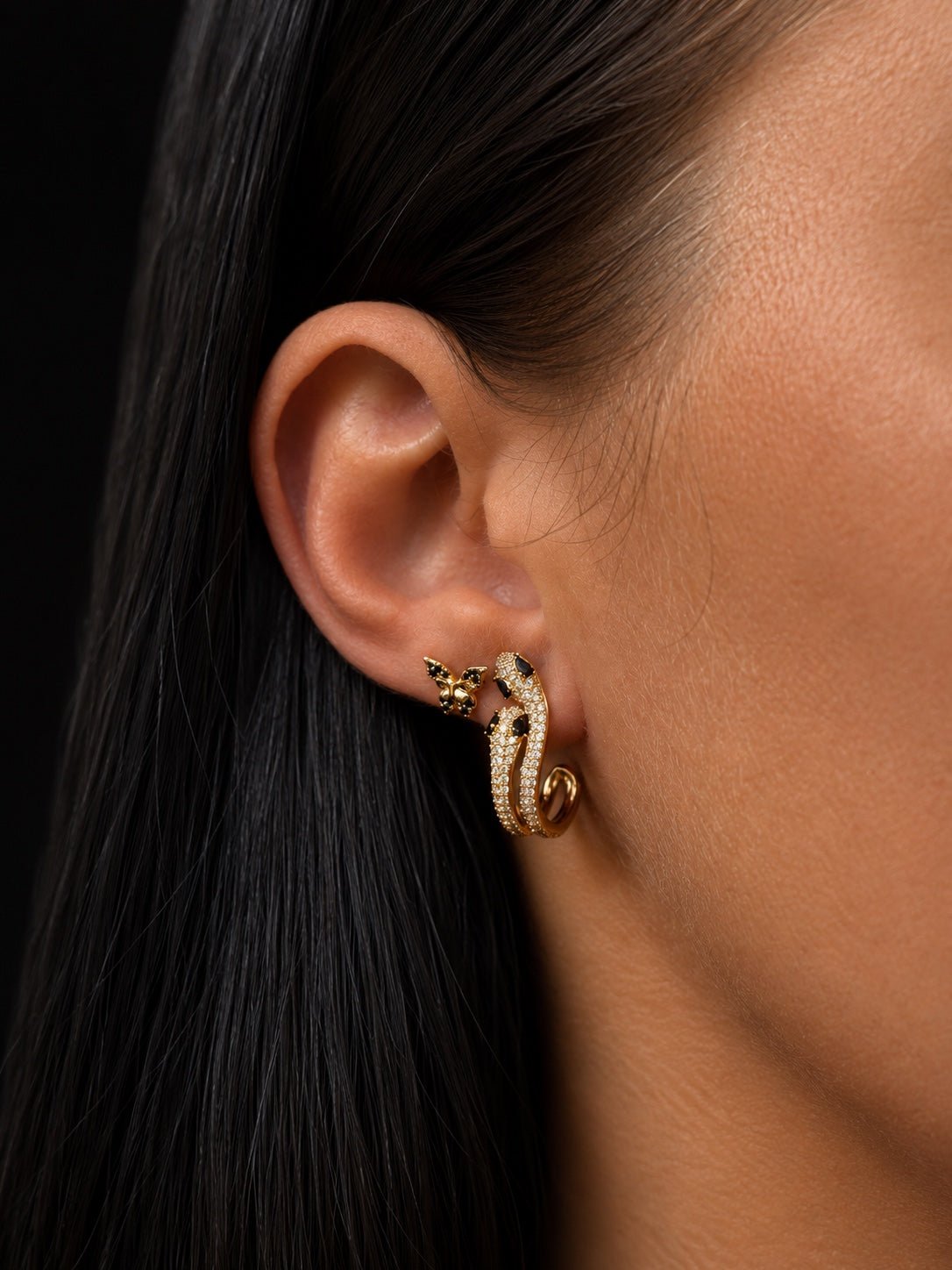 18K gold plated butterfly stud earrings with black cubic zirconia next to other earrings