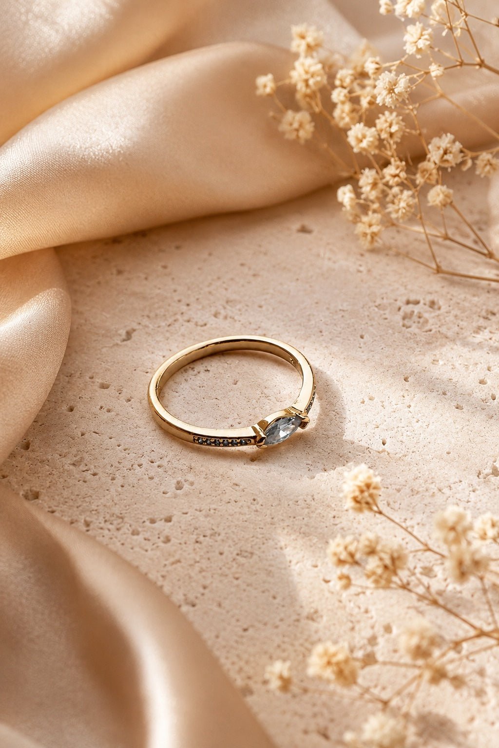 18k gold-plated delicate ring with marquise-shaped cubic zirconia on a light luxury background