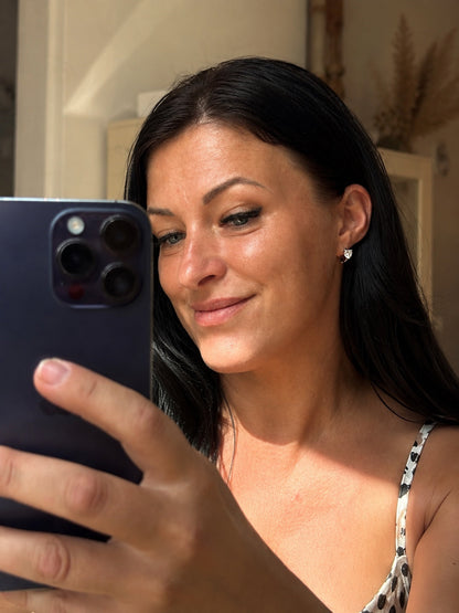 Alise apsudraboti riņķīšu auskari ar sirds formas cirkoniju pašportretā