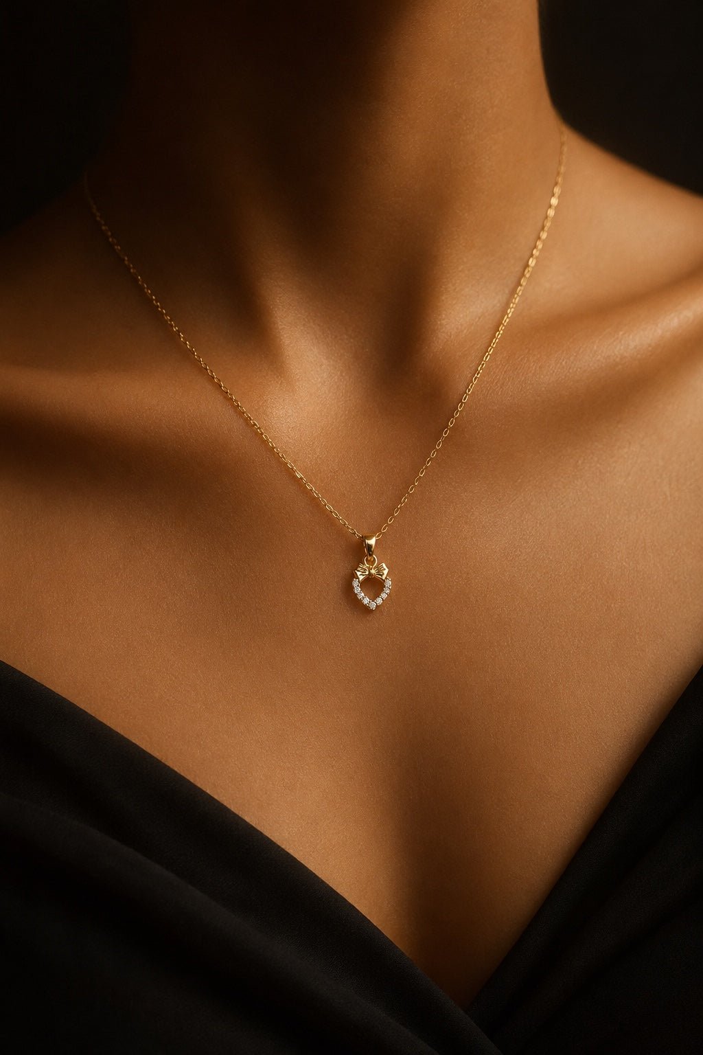 Delicate heart and bow pendant necklace on model