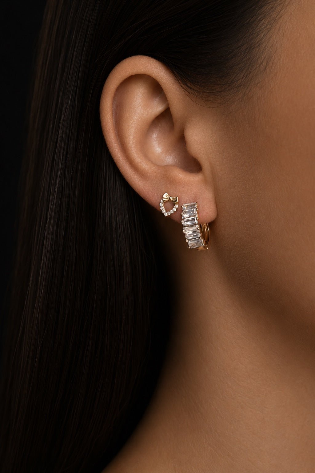 Delicate bow and heart stud earrings on the ear
