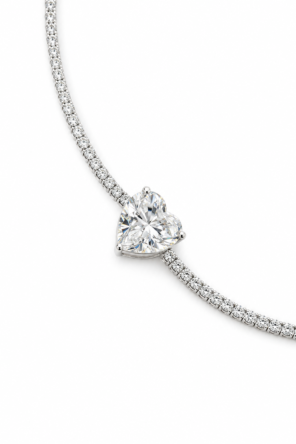 A close-up of a silver-plated bracelet with a heart-shaped crystal
