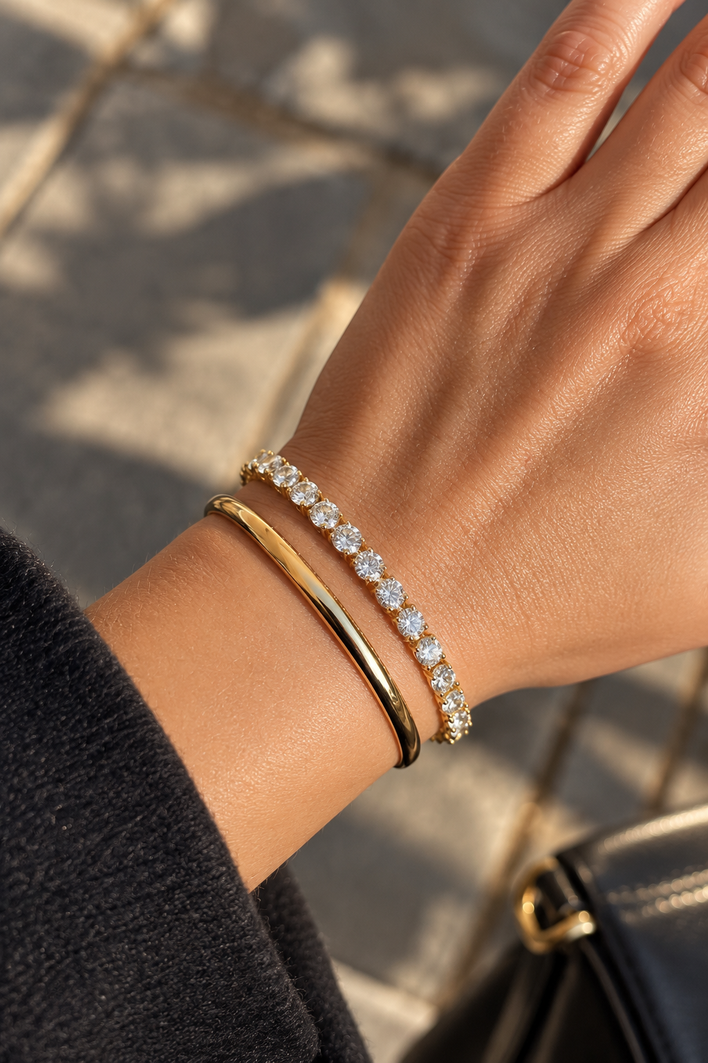 Apzeltīta bangle rokassprādze uz rokas pilsētvidē