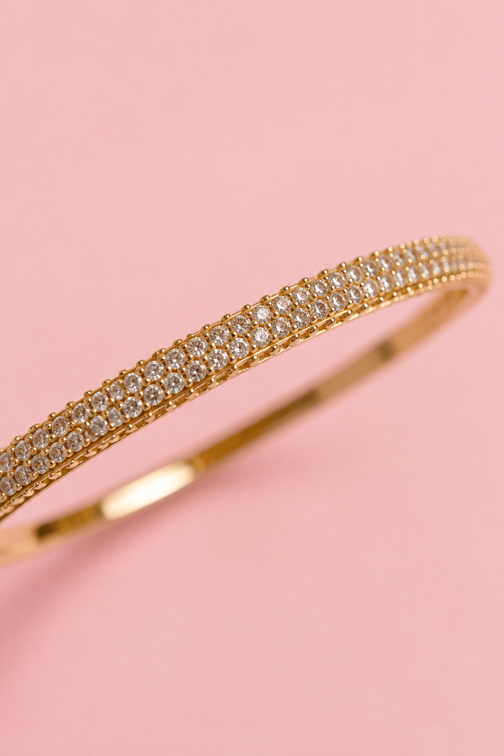 Close-up of a gold-plated bangle bracelet with cubic zirconia