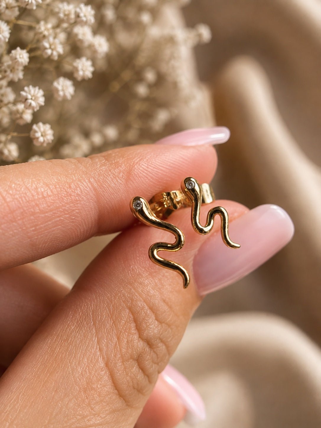 18K gold plated snake claw earrings close up with single cubic zirconia