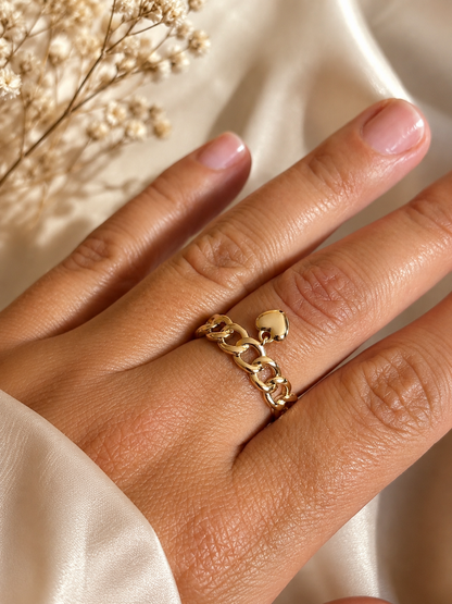 Chain ring with heart charm close-up on hand