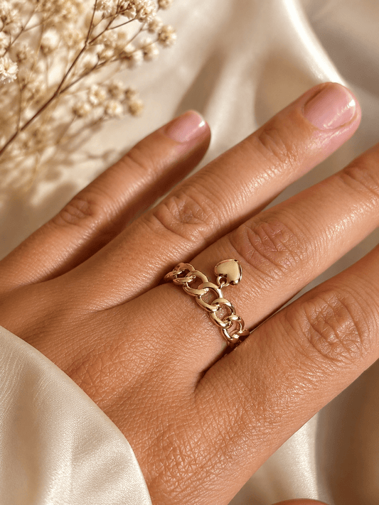 Chain ring with heart charm close-up on hand