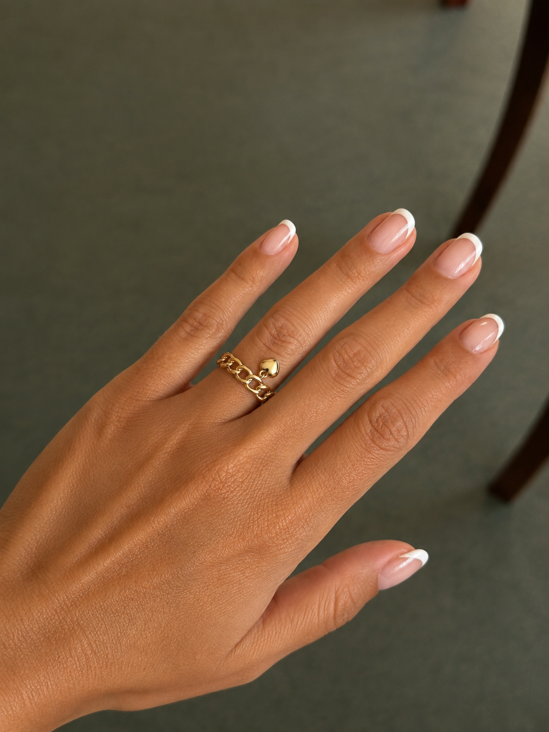 Chain ring with heart pendant on hand