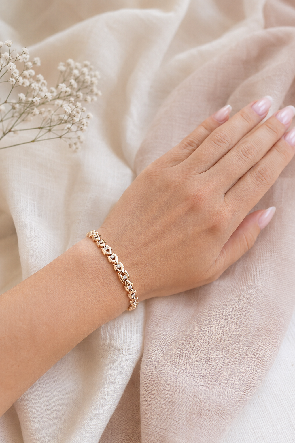 18k gold-plated bracelet with zircons on the hand on a light fabric background