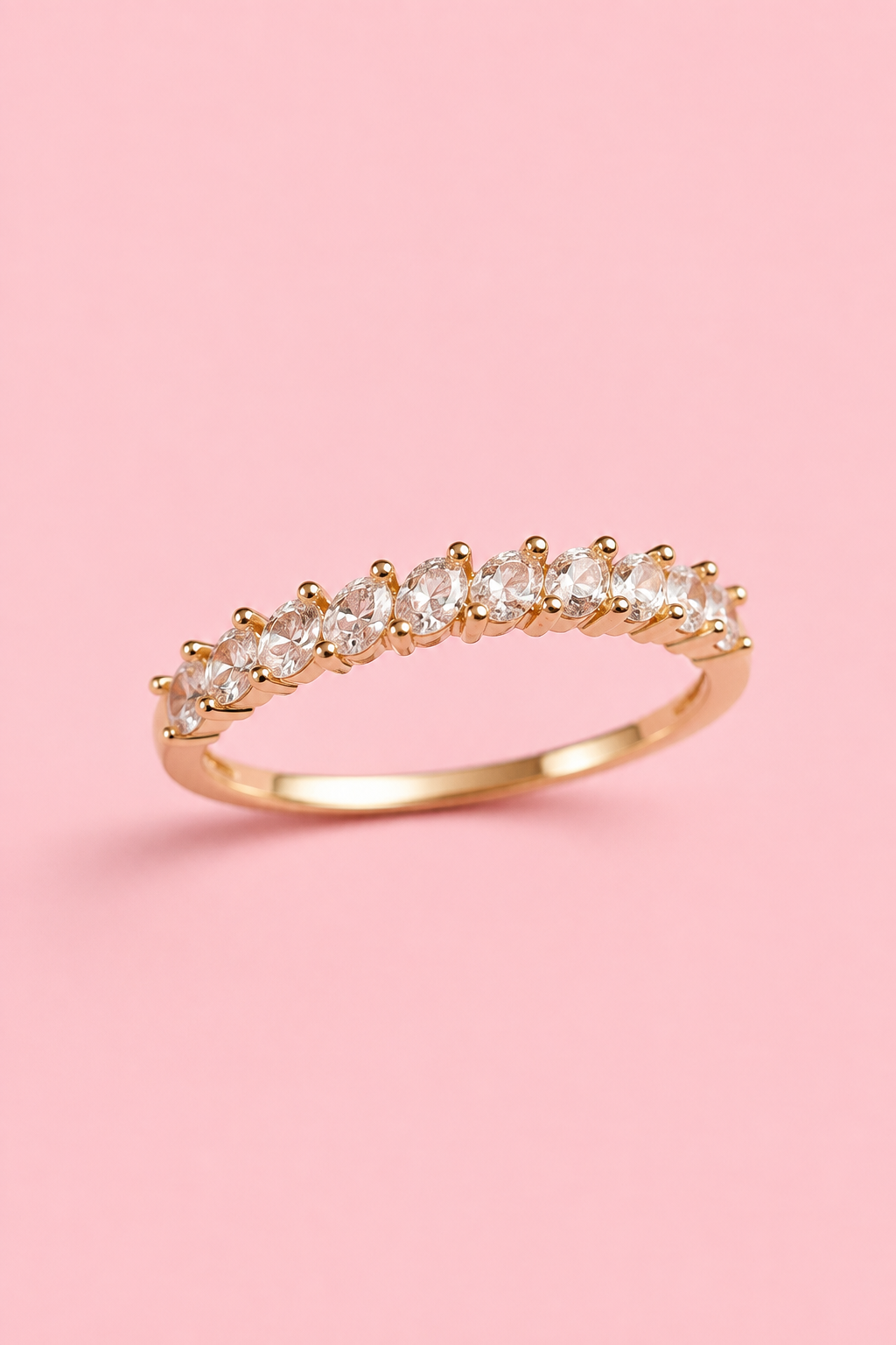 18k gold-plated ring with clear zircons on a pink background