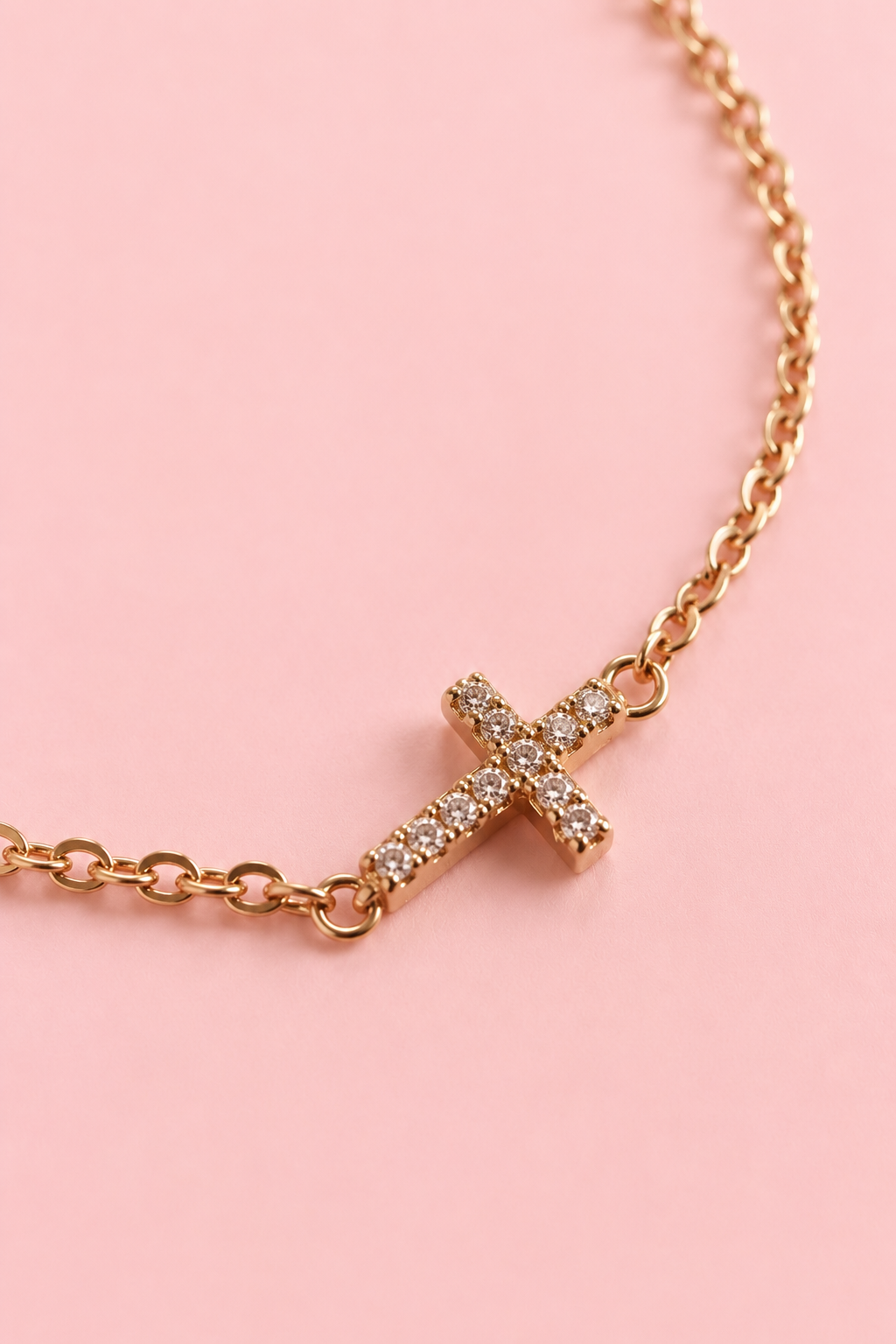 Close-up of 18k gold plated bracelet with clear cubic zirconia cross