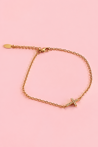 18k gold-plated bracelet with a zircon cross on a pink background