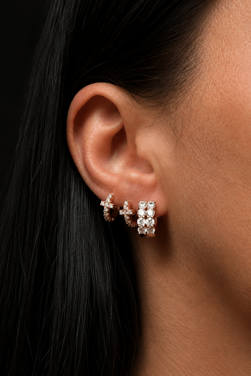 Mini hoop earrings with a zirconia cross in the ear and in the hole next to it