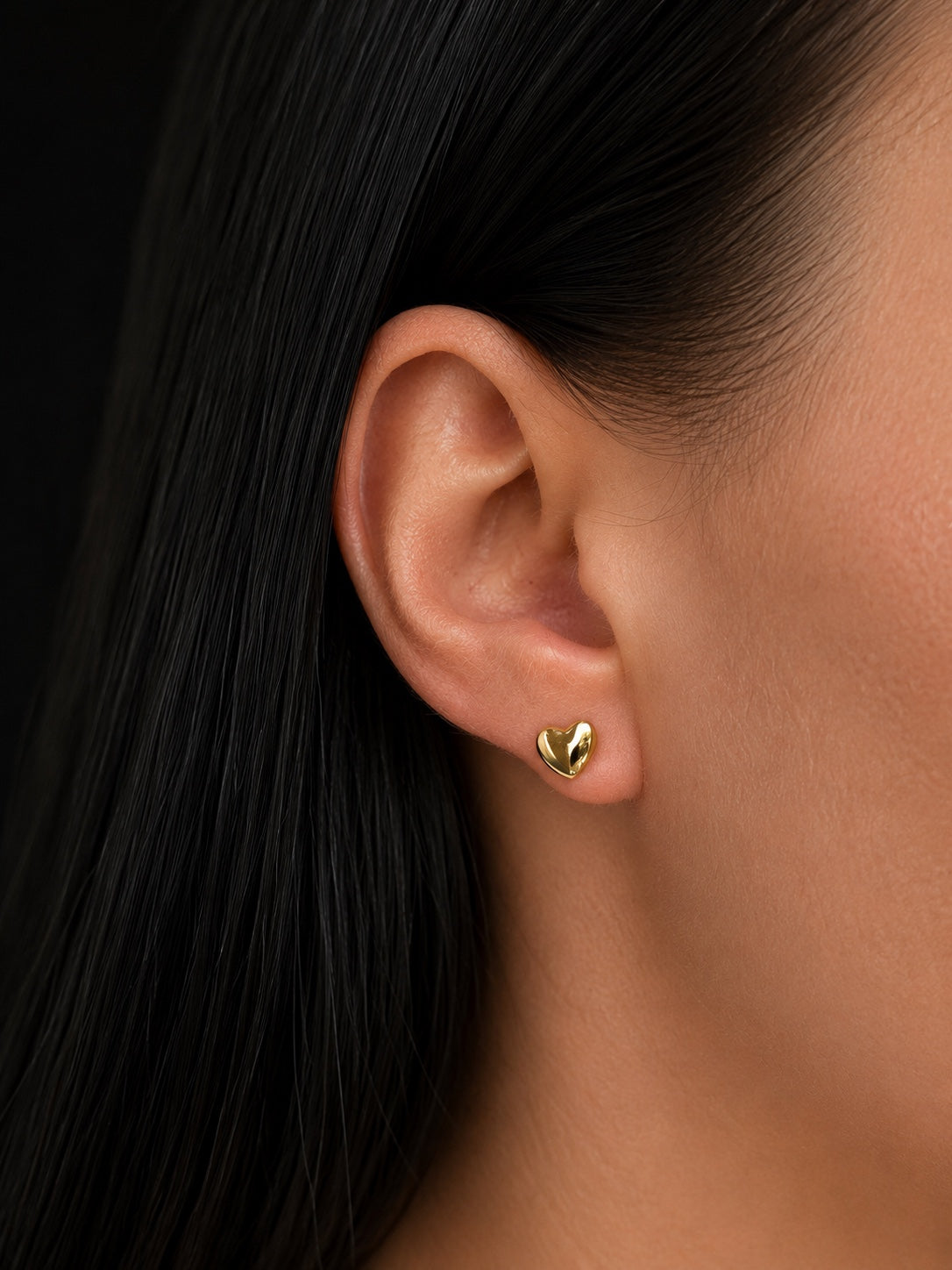 Sara's 18k gold-plated heart-shaped stud earrings on the ear
